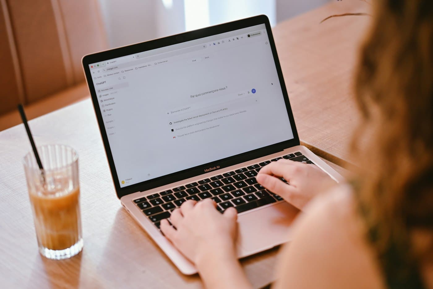 A person working on a laptop with an AI assistant chat open on the screen
